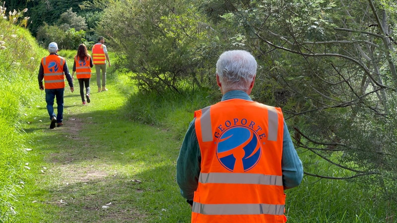 Geoporte engineers in branded vests walking a site